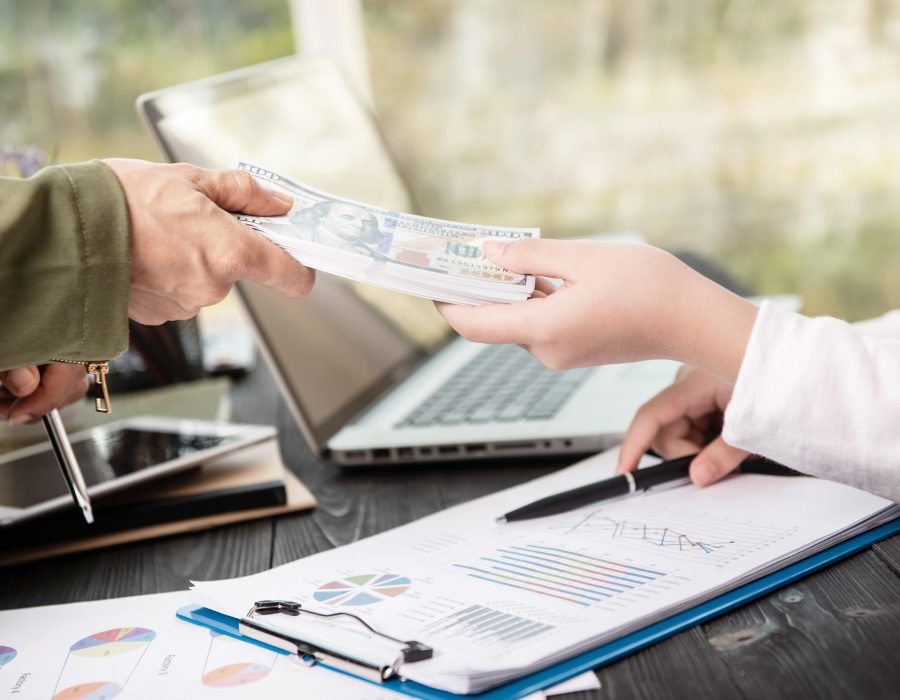 businessman-giving-money-his-partner-while-making-contract-min